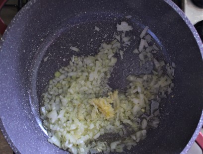 Onions and garlic sauteed in a pot with vegetable oil