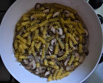 Pasta cooked with mushrooms in a wok