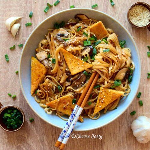 Stir fry noodles with tofu, mushrooms, spring onion and sesame seeds