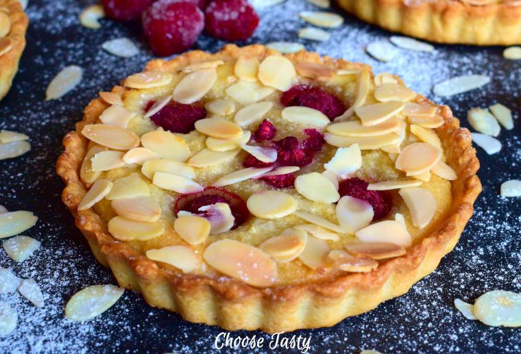 Raspberry frangipane mini tart decorated with almond flakes